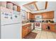 Cozy kitchen featuring wooden cabinets, white appliances, and tiled floors at 3401 Sunrise Villas S Ct, Tampa, FL 33614