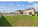 View of the grassy backyard, white fence, and the rear of the house at 2139 Stellar Brilliance Way, Lutz, FL 33558