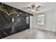 Bedroom features a stunning accent wall, ceiling fan and light-colored floors at 2139 Stellar Brilliance Way, Lutz, FL 33558