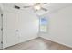 Comfortable bedroom features light wood floors, a ceiling fan, a window with blinds, and a door at 2139 Stellar Brilliance Way, Lutz, FL 33558