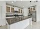 Open kitchen featuring white cabinets, granite countertops, stainless steel appliances, and a center island at 2139 Stellar Brilliance Way, Lutz, FL 33558
