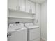 Convenient laundry room with modern washer and dryer, white cabinets, and shelving at 2139 Stellar Brilliance Way, Lutz, FL 33558