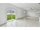Open living room with sliding glass doors to the backyard and view into kitchen at 2139 Stellar Brilliance Way, Lutz, FL 33558