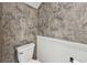Stylish powder room with gray wallpaper, white wainscoting, and modern fixtures at 2139 Stellar Brilliance Way, Lutz, FL 33558