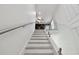 Modern staircase featuring sleek white risers, natural wood treads and glass railing at 2139 Stellar Brilliance Way, Lutz, FL 33558