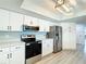 Cozy kitchen with white cabinets, stainless steel appliances and fixtures, and contemporary lighting at 3723 Toulouse Ct, Punta Gorda, FL 33950