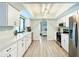 Charming kitchen showcasing white cabinets, stainless steel appliances, and an open view to the main bedroom at 3723 Toulouse Ct, Punta Gorda, FL 33950