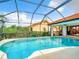 Inviting screened-in pool area with beautiful landscaping and clear blue water at 3723 Toulouse Ct, Punta Gorda, FL 33950