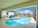 Relaxing screened-in pool with waterfront view, featuring an outdoor seating area and ample space at 3723 Toulouse Ct, Punta Gorda, FL 33950