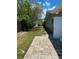 Exterior view of the backyard showing a paved walkway and lush vegetation, offering a serene outdoor space at 4571 Clearwater Harbor S Dr, Largo, FL 33770