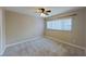 Neutral bedroom featuring a ceiling fan, plush carpet, and bright natural light from a large window at 4571 Clearwater Harbor S Dr, Largo, FL 33770