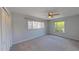 Airy bedroom featuring a ceiling fan, plush carpet, and natural light from large bright windows at 4571 Clearwater Harbor S Dr, Largo, FL 33770