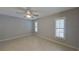 Neutral bedroom with tile floors, ceiling fan, and plantation shutters on the windows at 4571 Clearwater Harbor S Dr, Largo, FL 33770