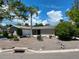 Well-maintained single-story home featuring a grey facade, complemented by a lush palm tree in the front yard at 4571 Clearwater Harbor S Dr, Largo, FL 33770