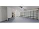 Garage with roll-up door and equipment including an AC system against the back wall with painted floor at 4571 Clearwater Harbor S Dr, Largo, FL 33770