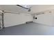 Spacious garage with a roll-up door, painted floor, and overhead lighting, ready for parking or storage at 4571 Clearwater Harbor S Dr, Largo, FL 33770