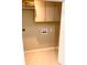Small laundry area with tiled flooring and overhead storage at 4571 Clearwater Harbor S Dr, Largo, FL 33770