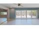 Bright living room with sliding glass doors, neutral tile flooring, and fan at 4571 Clearwater Harbor S Dr, Largo, FL 33770