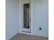 Close up of back door with white trim and neutral colored siding at 130 Bragg Ln, Lakewood Ranch, FL 34240