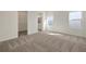 Carpeted bedroom with closet and bathroom entrances, featuring abundant natural light at 130 Bragg Ln, Lakewood Ranch, FL 34240