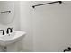 Elegant pedestal sink with black hardware in this bathroom at 145 Thorne Ln, Lakewood Ranch, FL 34240