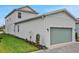 Exterior showing the garage of the house, with its light green doors and adjacent well-maintained lawn at 145 Thorne Ln, Lakewood Ranch, FL 34240