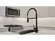 Modern kitchen with stainless steel appliances and a black faucet at 145 Thorne Ln, Lakewood Ranch, FL 34240