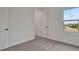 Bright bedroom with neutral carpet and a large window showing treelined street with roof top at 164 Eagleston Ln, Lakewood Ranch, FL 34240