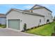 Two car garage with a green door and landscaping on the side of a new build home at 164 Eagleston Ln, Lakewood Ranch, FL 34240