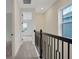 Bright hallway features a black railing and neutral carpet leading to an adjacent room with natural light at 164 Eagleston Ln, Lakewood Ranch, FL 34240