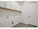 Laundry room with white cabinets, gray tile flooring and multiple hookups at 164 Eagleston Ln, Lakewood Ranch, FL 34240