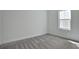 A simple bedroom with a window providing natural light over light gray carpeted flooring at 9035 Duany Ln, Lakewood Ranch, FL 34240