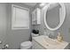 Well-lit bathroom with a white vanity, toilet and large mirror at 8897 54Th N St, Pinellas Park, FL 33782