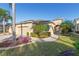 Tan two-car garage home with landscaping and walkway at 2429 Nottingham Greens Dr # 118, Sun City Center, FL 33573