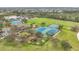Sprawling aerial view featuring the pool, clubhouse, playground, tennis courts, and a scenic green space at 4808 111Th E Ter, Parrish, FL 34219