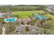 Comprehensive aerial view showcases the pool, clubhouse, tennis courts, playground, and surrounding lush landscape at 4808 111Th E Ter, Parrish, FL 34219