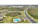 Aerial view of community pool, pond, and surrounding neighborhood at 4808 111Th E Ter, Parrish, FL 34219