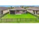 Back view of home, highlighting screened lanai, fenced backyard, and well-manicured lawn at 4808 111Th E Ter, Parrish, FL 34219