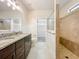 Bathroom featuring granite countertops, double sinks, and a tiled walk-in shower at 4808 111Th E Ter, Parrish, FL 34219