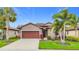Inviting single-story home with a two-car garage, manicured lawn, and tropical landscaping at 4808 111Th E Ter, Parrish, FL 34219