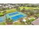 Aerial view of well-maintained tennis courts with blue and green surfaces surrounded by green spaces and palm trees at 4808 111Th E Ter, Parrish, FL 34219