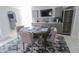 Dining room featuring a round table with seating for four, a bar area, and modern gray cabinets at 817 Blue Heron Blvd, Ruskin, FL 33570