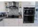 Kitchen showcasing black stainless steel appliances, white cabinets, and stylish backsplash at 817 Blue Heron Blvd, Ruskin, FL 33570
