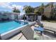 Resort-style pool area with comfortable lounge chairs and a covered dining area for outdoor enjoyment at 817 Blue Heron Blvd, Ruskin, FL 33570