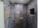 Luxurious shower with dark marble-look tiles, a niche, and brass hardware fixtures at 817 Blue Heron Blvd, Ruskin, FL 33570