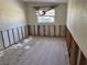 An empty bedroom with damaged drywall, exposed framing, and a window with a view of the outdoors at 9015 Bay Ne St, St Petersburg, FL 33702