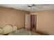Cozy bedroom with a ceiling fan, striped bedding, and open door leading to another room at 3604 Bula Ln, North Port, FL 34287