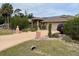 Charming exterior view showing well-maintained landscaping, driveway, and solar panels on the roof at 3604 Bula Ln, North Port, FL 34287