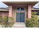 Inviting front entrance with double doors, arched transom window, and colorful landscaping at 3604 Bula Ln, North Port, FL 34287