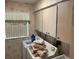 Functional laundry room with washer, dryer, overhead cabinets and a bright window providing natural light at 3604 Bula Ln, North Port, FL 34287